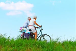 Un couple de personnes âgées faisant du vélo.
