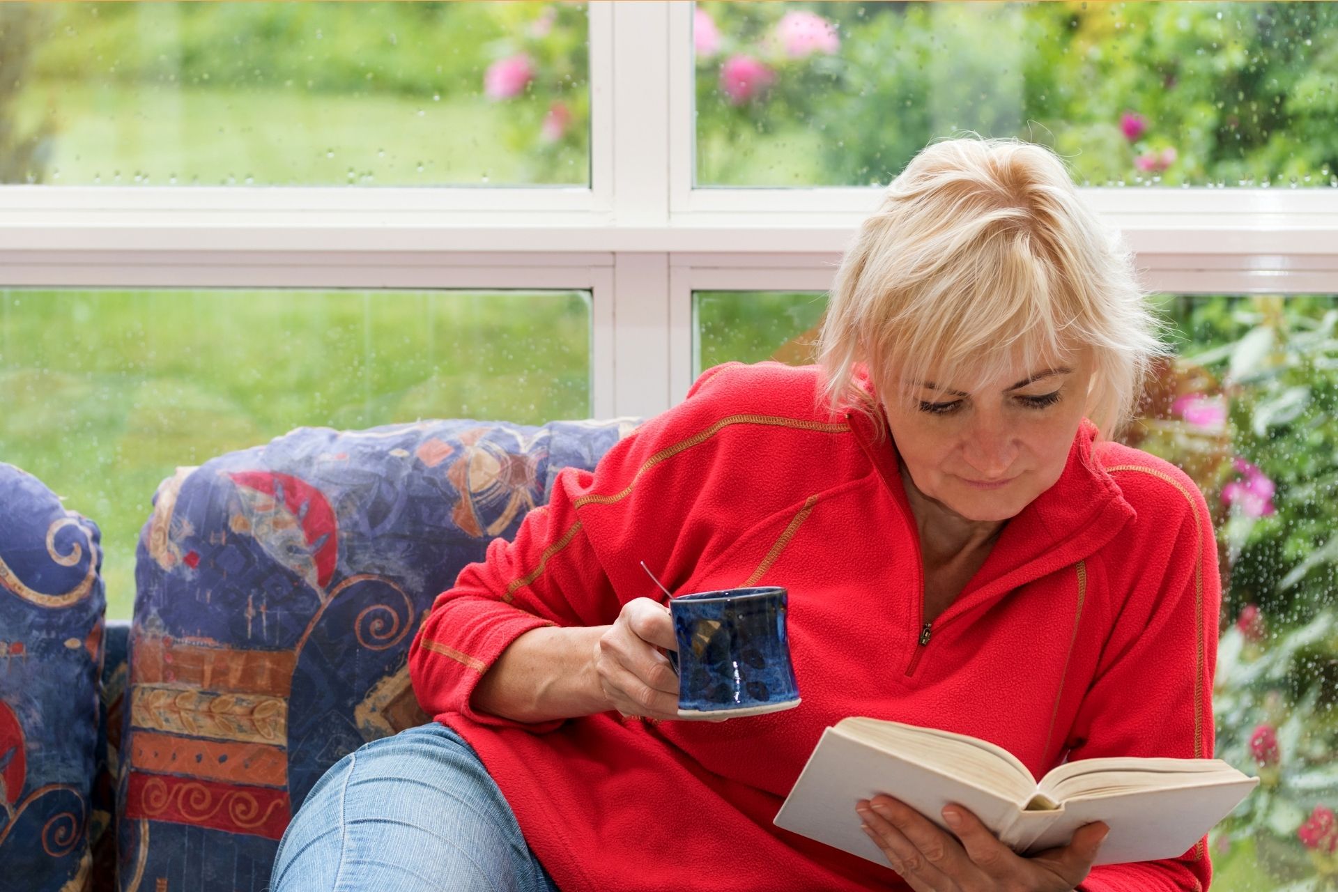 Femme faisant la lecture d'un livre avec tisane.